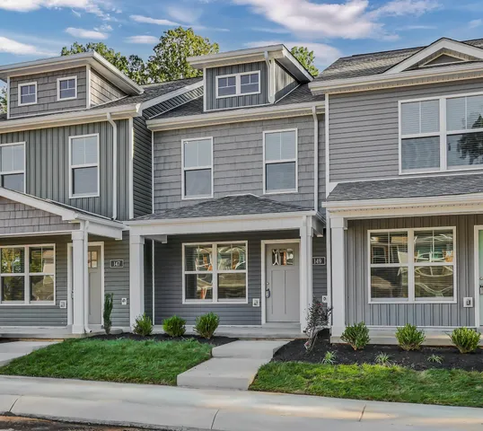 a front view of a house with a yard and plants