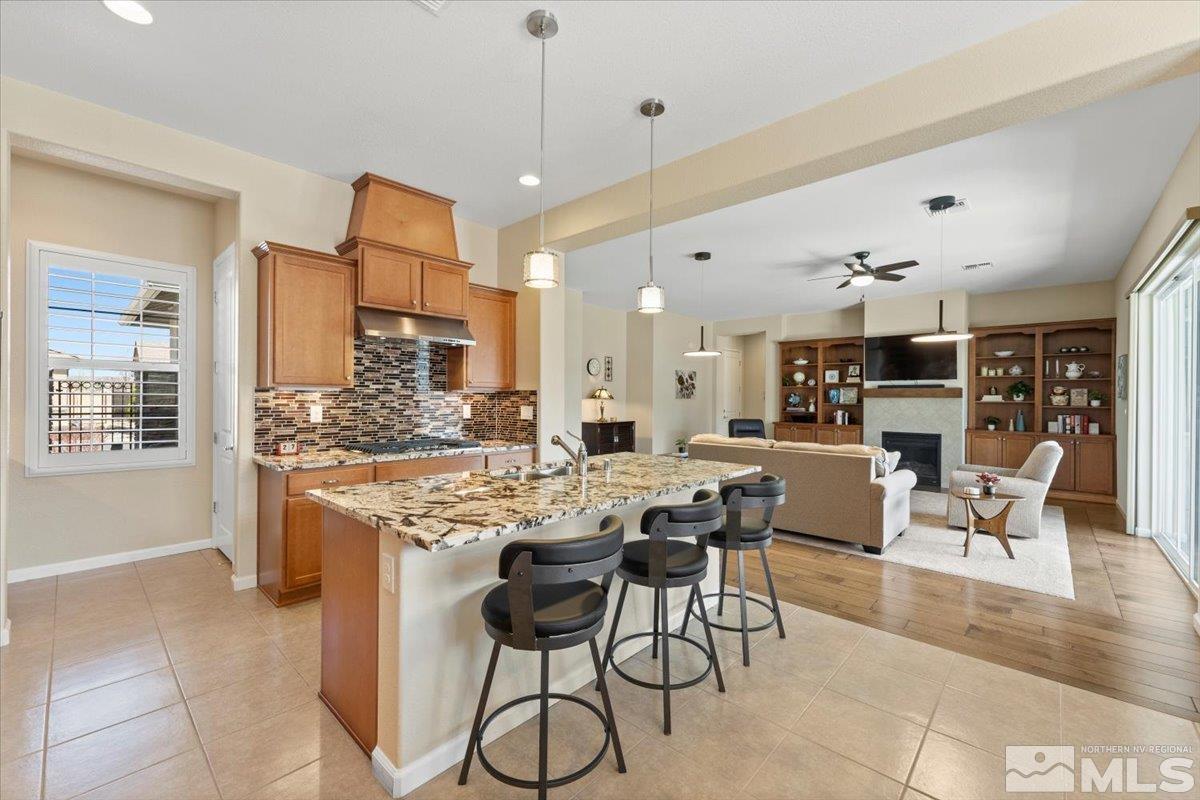 2300 Arpagos Lane Reno, NV 89521 - Photo 12 of 40 a dining hall with stainless steel appliances kitchen island granite countertop a table and chairs in it