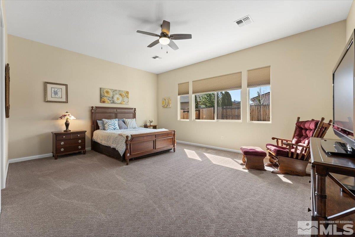 2300 Arpagos Lane Reno, NV 89521 - Photo 15 of 40 a spacious bedroom with a bed and a chandelier