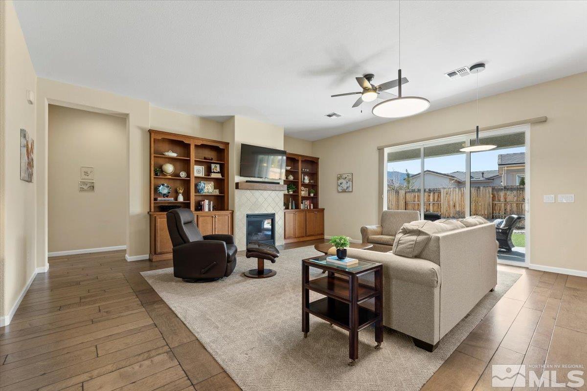 2300 Arpagos Lane Reno, NV 89521 - Photo 6 of 40 a living room with furniture a chandelier and a fireplace