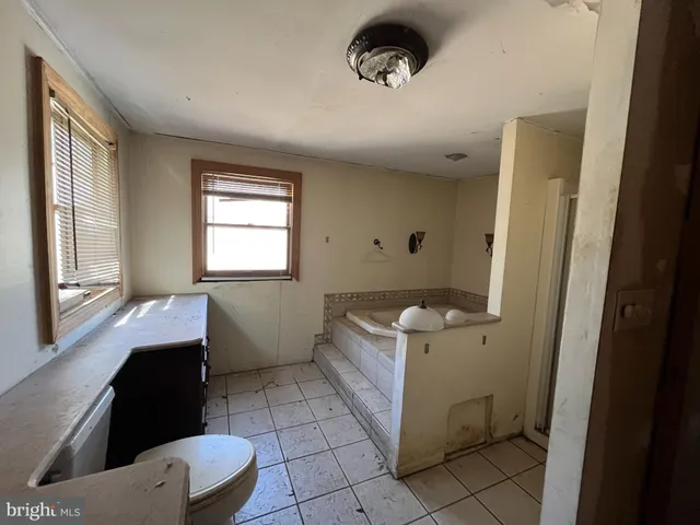 a bathroom with a toilet a sink and a window