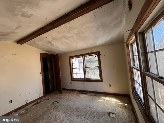 a view of empty room with wooden floor and windows