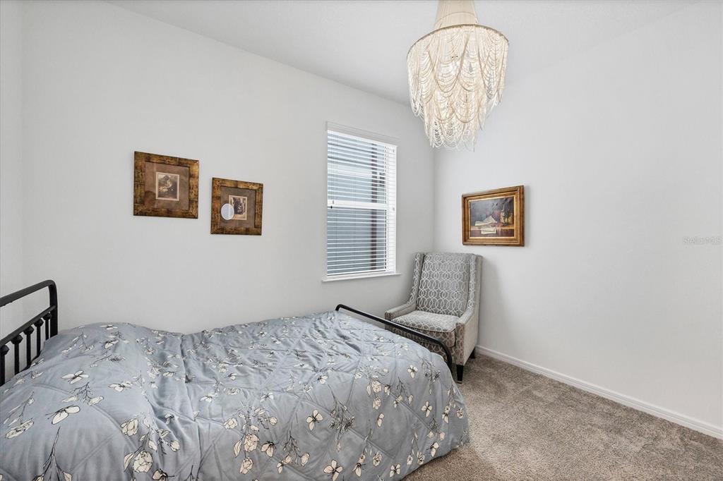 9528 Lamine Way Parrish, FL 34219 - Photo 9 of 58 a bedroom with a bed and a chandelier