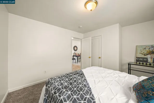 a bedroom with a bed and a lamp on the dresser