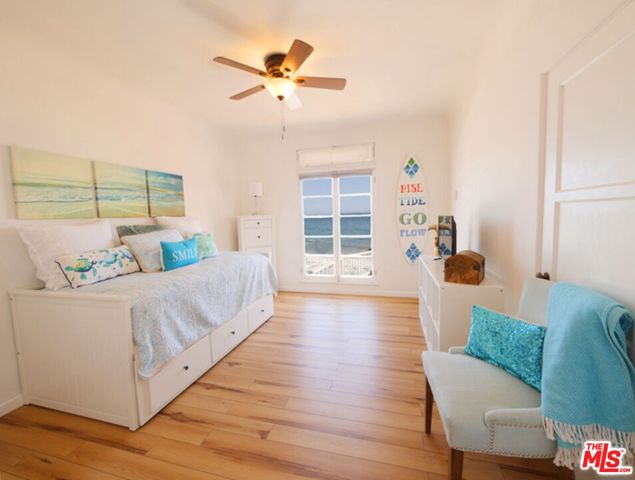 a spacious bedroom with a bed and wooden floor
