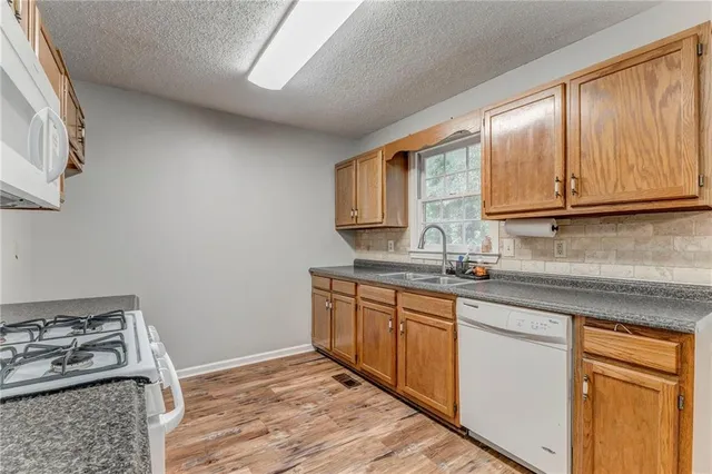 a kitchen with stainless steel appliances granite countertop a sink stove and cabinets