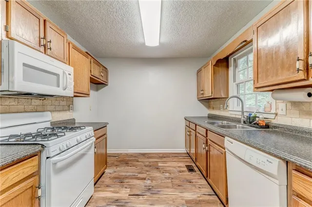 a kitchen with stainless steel appliances granite countertop a stove a sink and a microwave