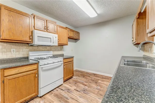 a kitchen with stainless steel appliances granite countertop a sink stove and cabinets