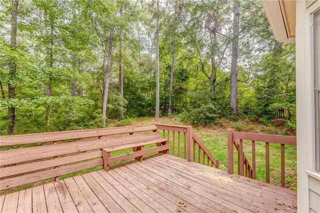 a view of a wooden deck and trees in the background
