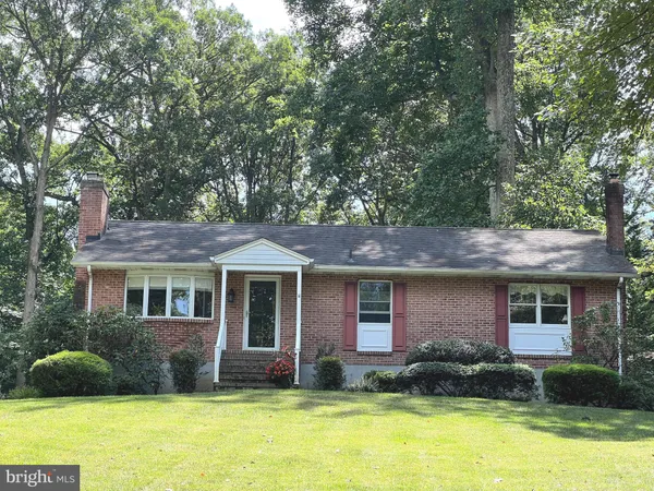 a front view of a house with a yard and trees
