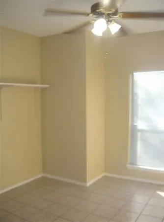 a view of a small space with wooden floor and a window