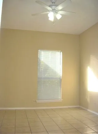 an empty room with a chandelier fan