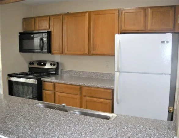 a kitchen with a refrigerator sink and cabinets