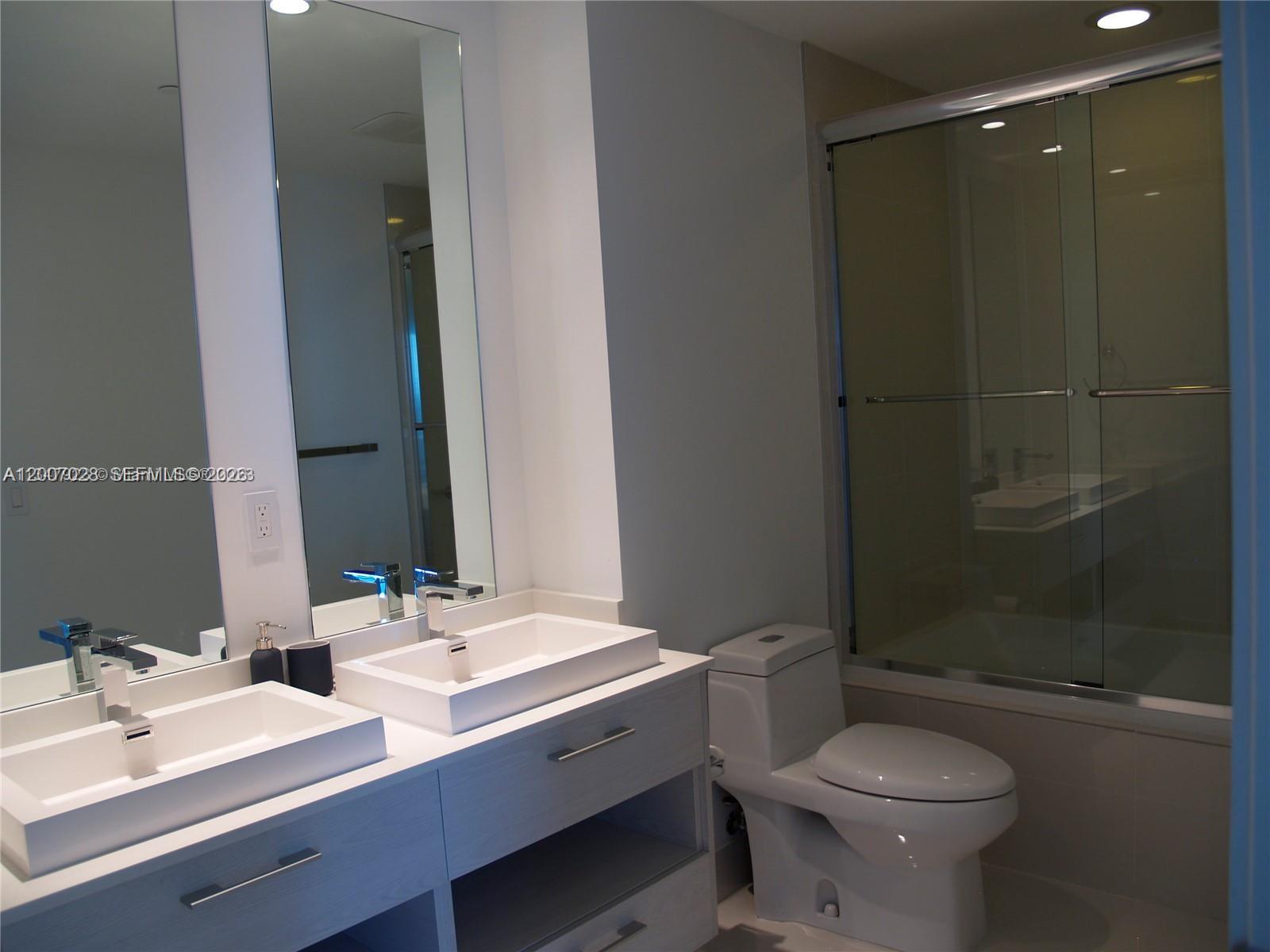 55 Southwest 9th Street, Unit 2502 Miami, FL 33130 - Photo 3 of 27 a bathroom with a double vanity sink toilet and shower