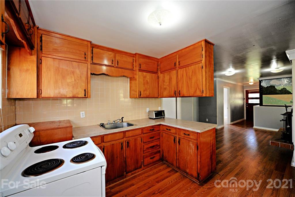 1 Sycamore Street Asheville, NC 28804 - Photo 33 of 46 a kitchen with stainless steel appliances kitchen island granite countertop a sink stove and cabinets