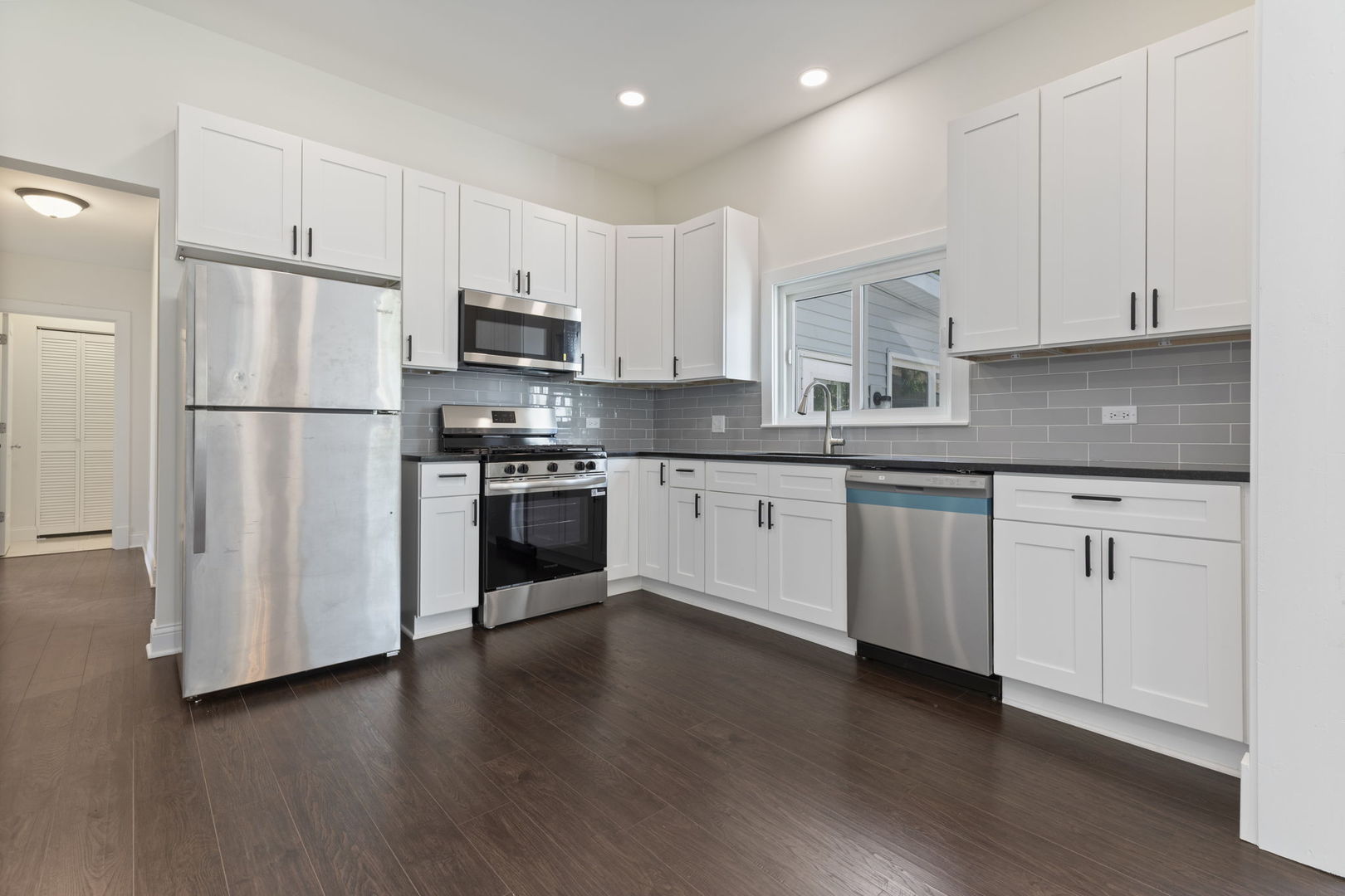 718 Sycamore Street Ottawa, IL 61350 - Photo 10 of 27 a kitchen with white cabinets stainless steel appliances and a sink