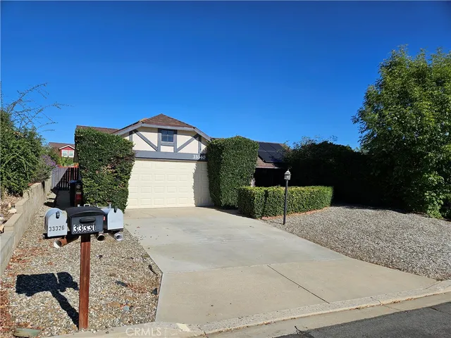 a view of a house with a yard and large tree