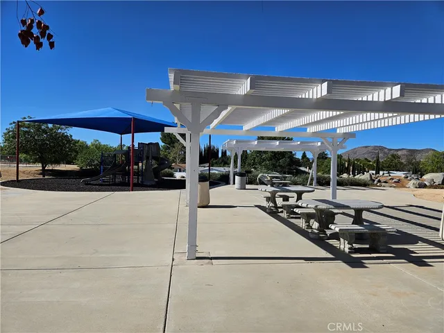 a view of a patio with a table and chairs under an umbrella