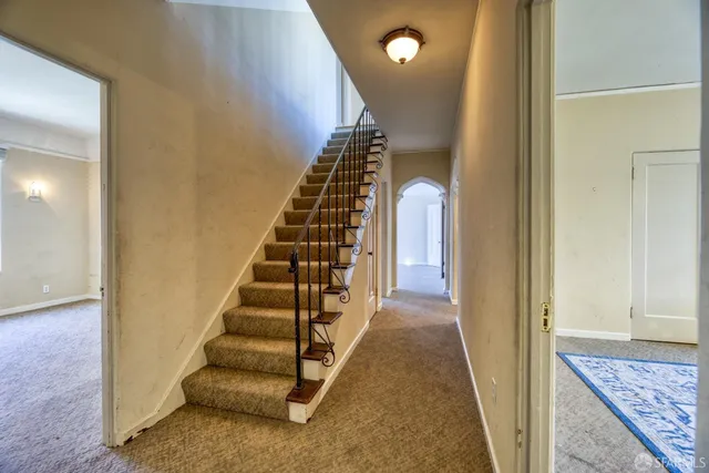 a view of an empty room with cabinet and a window