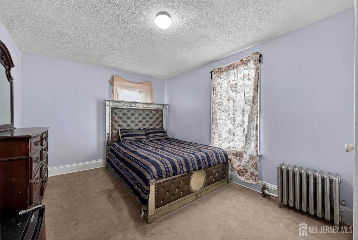 361 Prospect Street Perth Amboy, NJ 08861 - Photo 28 of 50 a bedroom with a bed and a chair
