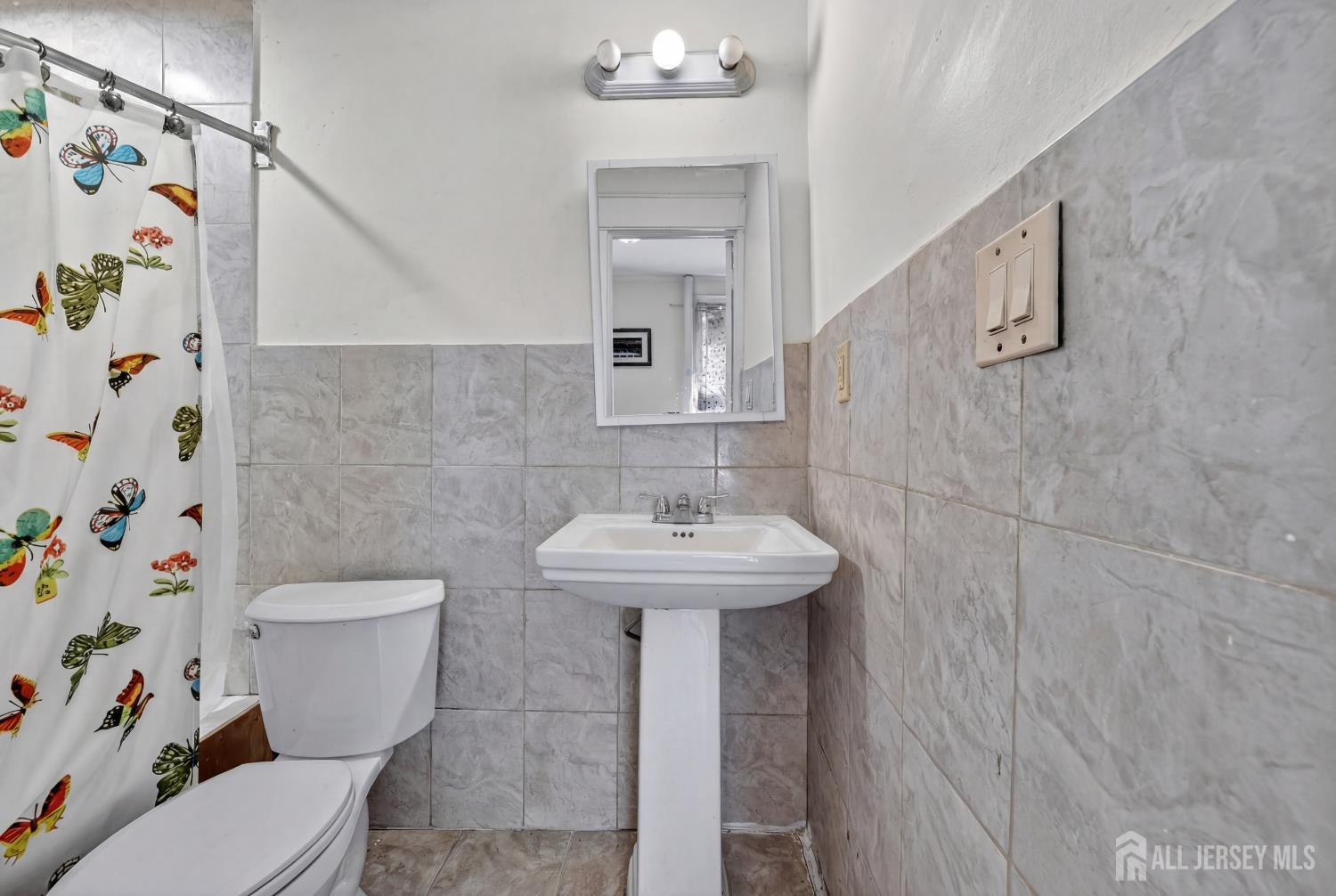 361 Prospect Street Perth Amboy, NJ 08861 - Photo 32 of 50 a bathroom with a sink a toilet and a mirror