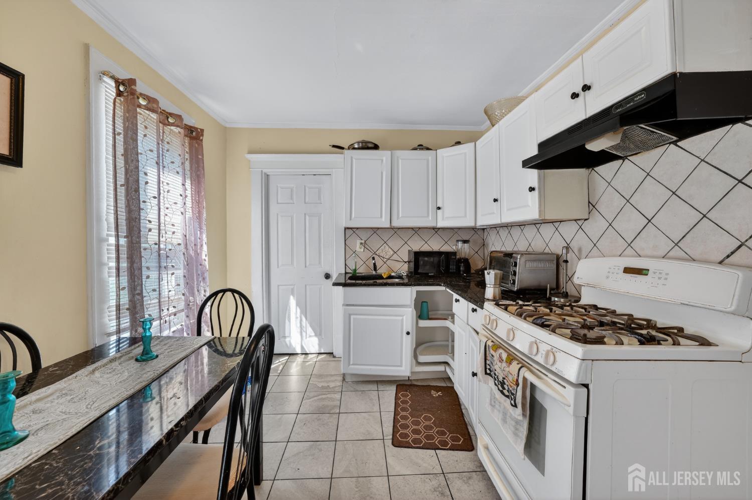 361 Prospect Street Perth Amboy, NJ 08861 - Photo 4 of 50 a kitchen with granite countertop a stove a sink and a refrigerator