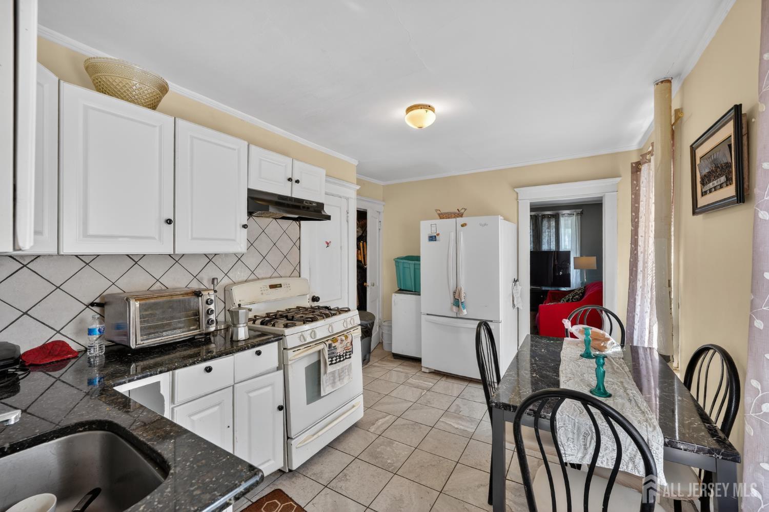 361 Prospect Street Perth Amboy, NJ 08861 - Photo 5 of 50 a kitchen with stainless steel appliances granite countertop a stove a sink dishwasher and white cabinets with wooden floor