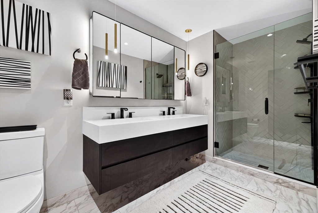 55 Lagrange Street, Unit 409 Boston, MA 02111 - Photo 15 of 29 a bathroom with a sink shower and a mirror