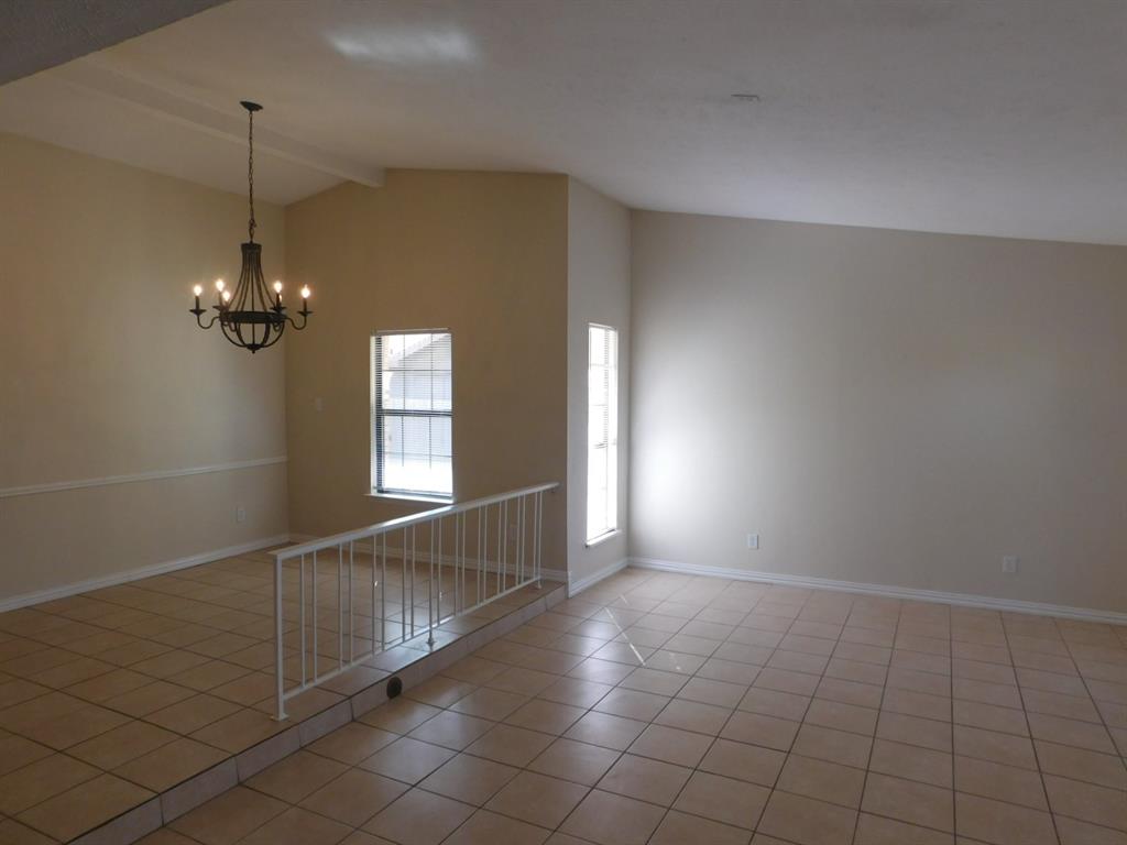 10371 White Elm Road Dallas, TX 75243 - Photo 3 of 11 Empty room with light tile patterned floors and a chandelier