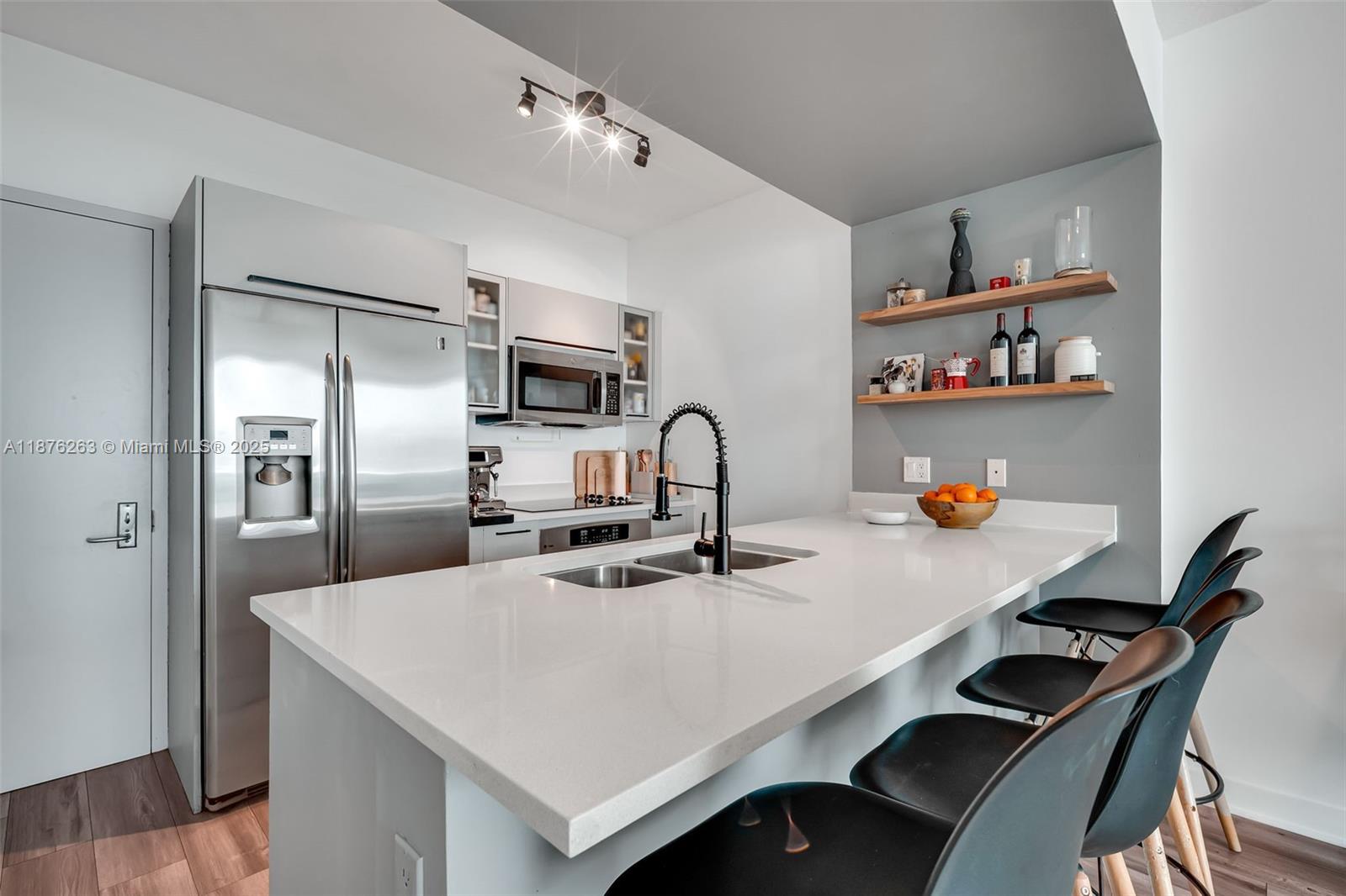 333 Northeast 24th Street, Unit 1111 Miami, FL 33137 - Photo 13 of 39 a kitchen with kitchen island a stove a sink and a refrigerator
