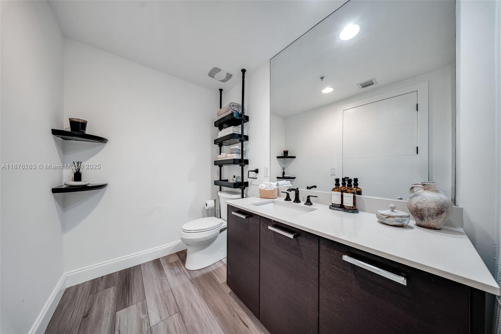 333 Northeast 24th Street, Unit 1111 Miami, FL 33137 - Photo 24 of 39 a bathroom with a double vanity sink toilet and a mirror