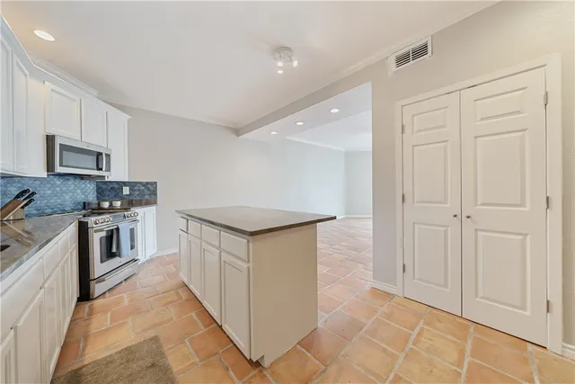 a spacious bedroom with a large bed and a chandelier