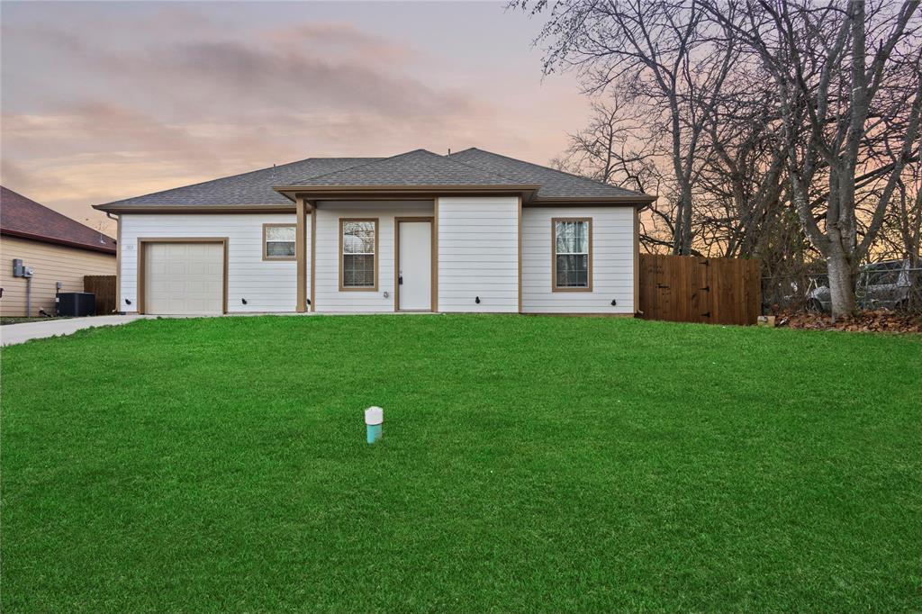 a view of a house with a yard and large trees