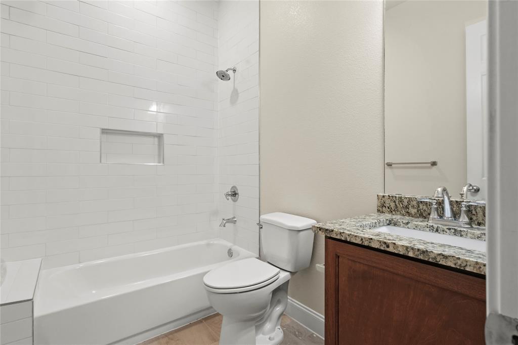 503 South 5th Street Bonham, TX 75418 - Photo 15 of 22 a bathroom with a granite countertop toilet a sink and bathtub