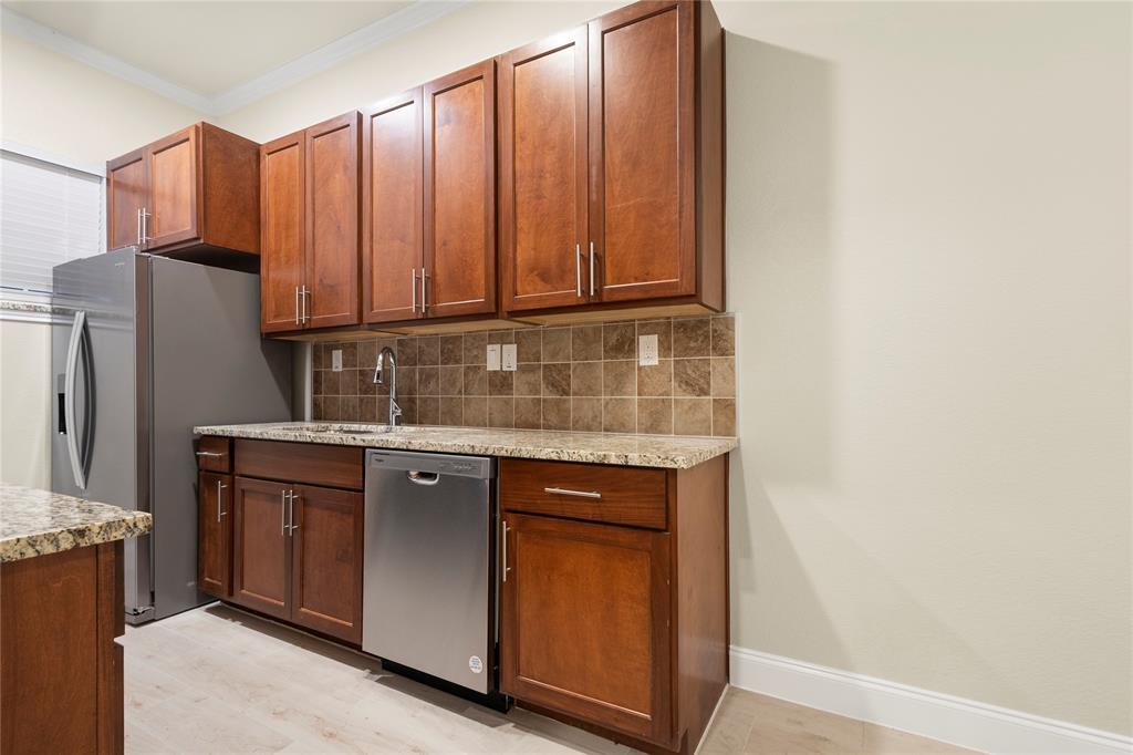 503 South 5th Street Bonham, TX 75418 - Photo 4 of 22 a kitchen with stainless steel appliances granite countertop a sink and a refrigerator