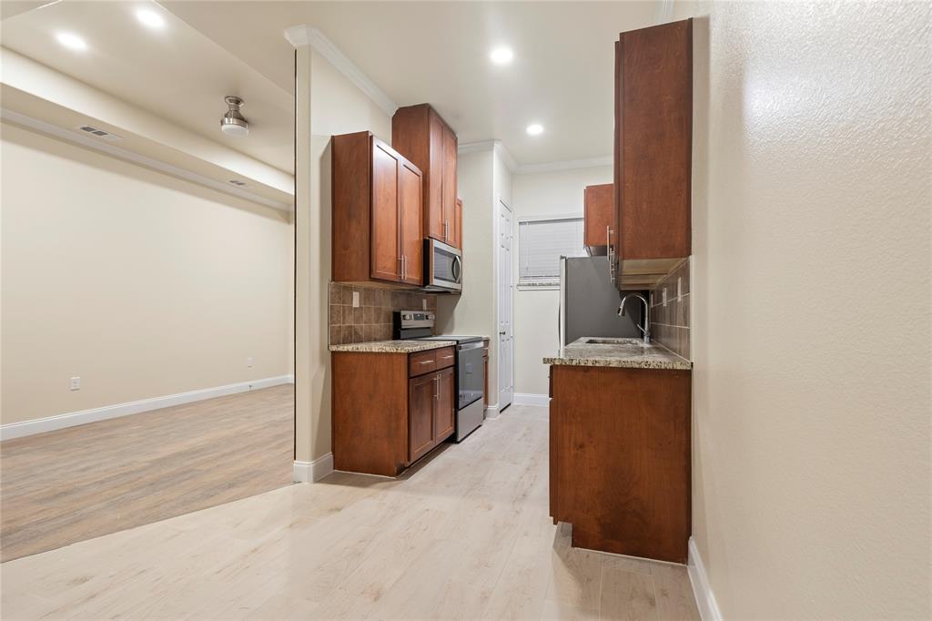 503 South 5th Street Bonham, TX 75418 - Photo 5 of 22 a kitchen with sink refrigerator and cabinets