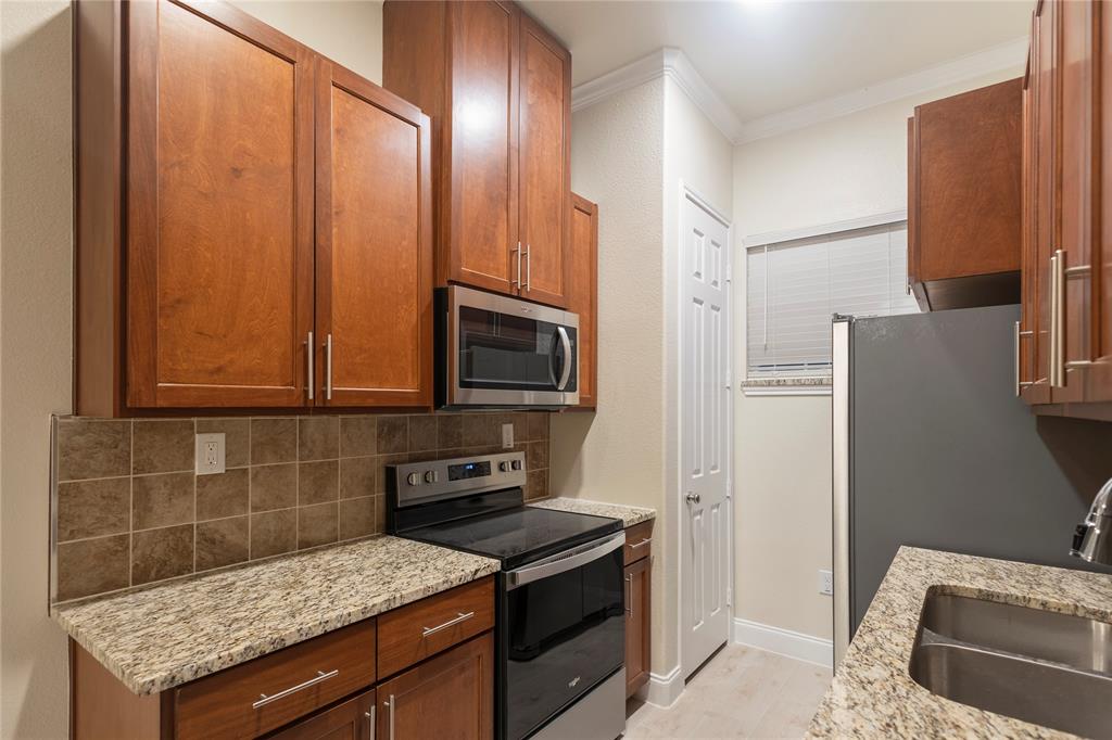503 South 5th Street Bonham, TX 75418 - Photo 6 of 22 a kitchen with stainless steel appliances granite countertop a stove a refrigerator and a microwave