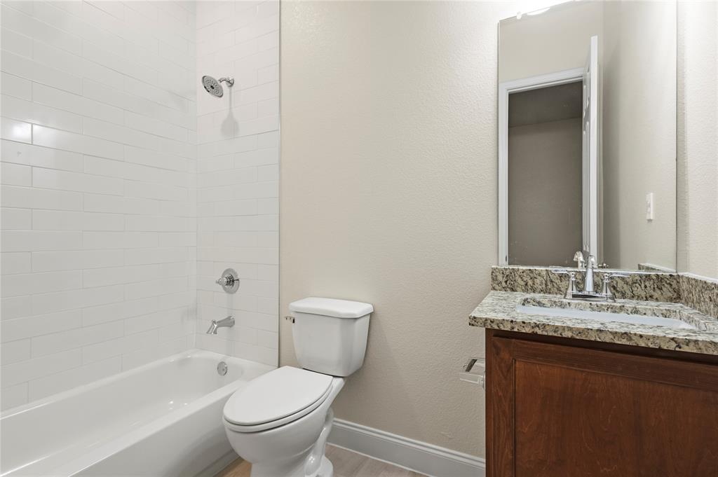 503 South 5th Street Bonham, TX 75418 - Photo 10 of 22 a bathroom with a granite countertop sink toilet and shower