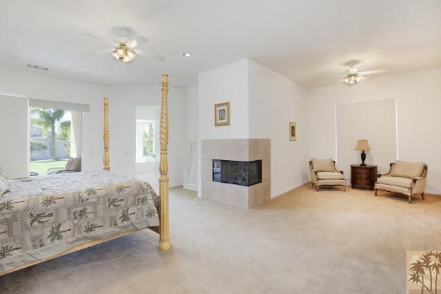 5 Champagne Circle Rancho Mirage, CA 92270 - Photo 13 of 24 a spacious bedroom with furniture and a fireplace