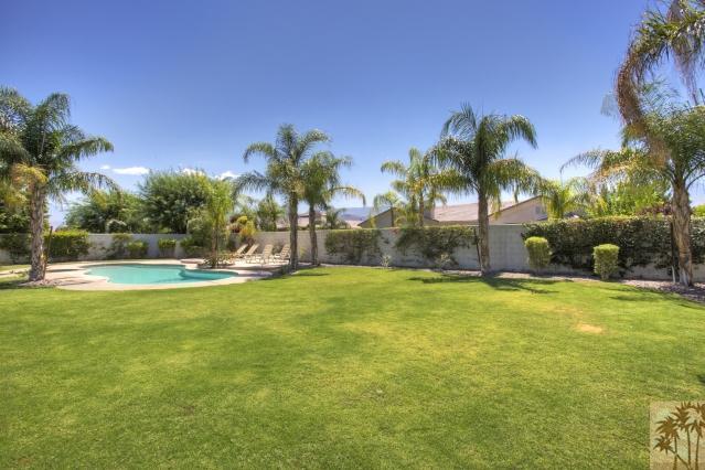 5 Champagne Circle Rancho Mirage, CA 92270 - Photo 20 of 24 a view of a swimming pool with a yard and palm trees