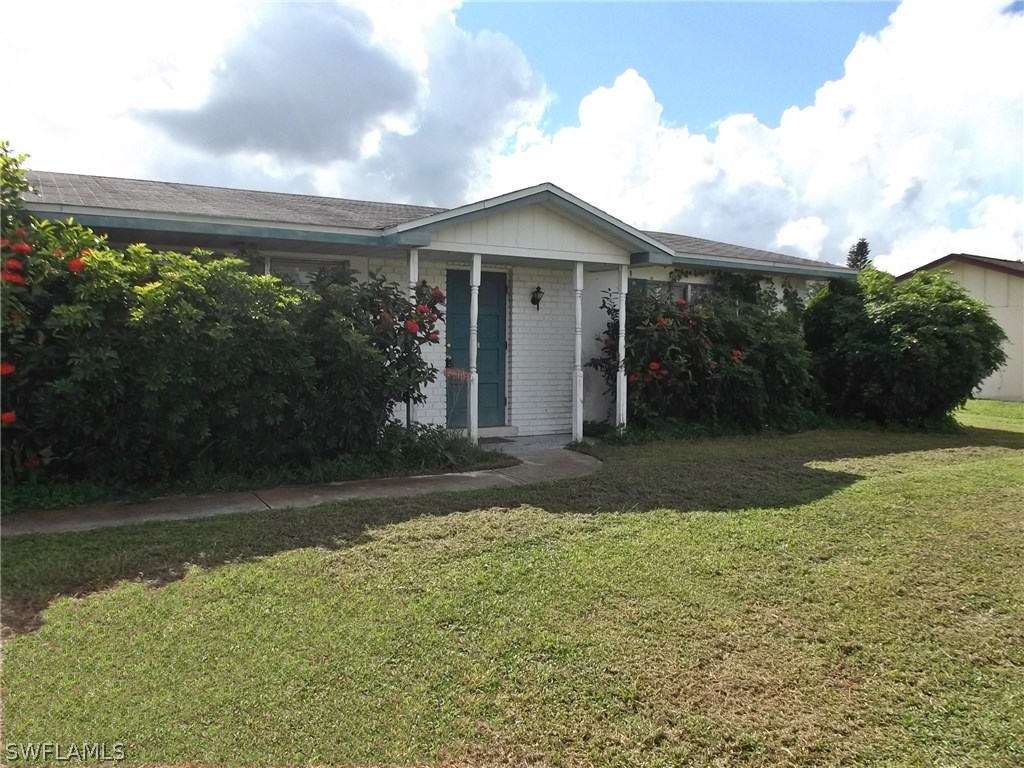 108 Rowland Road Lehigh Acres, FL 33936 - Photo 1 of 8 a front view of house with yard and green space