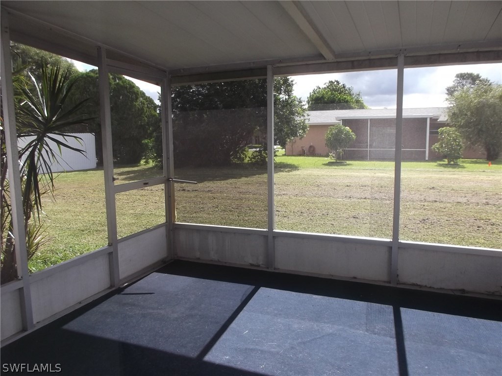 108 Rowland Road Lehigh Acres, FL 33936 - Photo 4 of 8 a view of a porch with wooden floor and outdoor space