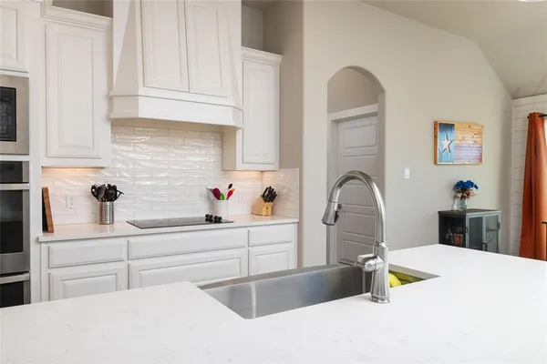 a kitchen with a sink refrigerator and cabinets