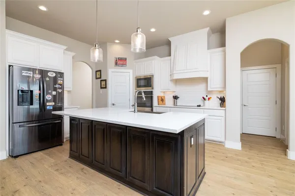 a kitchen with kitchen island a sink stainless steel appliances and cabinets