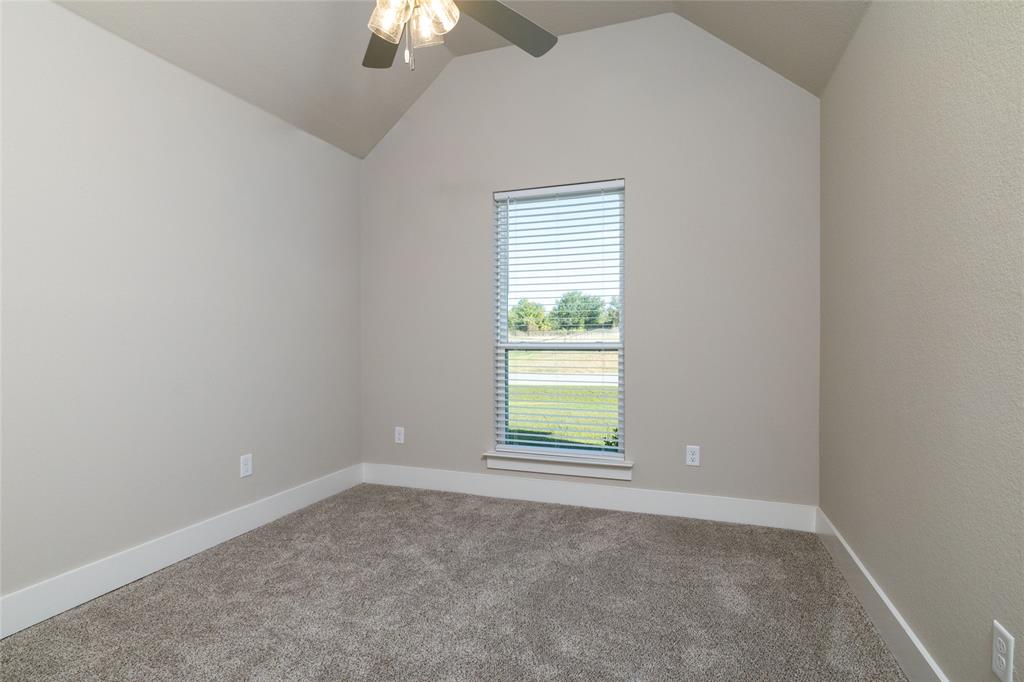 321 Monument Pl. Azle, TX 76020 - Photo 20 of 37 Carpeted spare room featuring vaulted ceiling and ceiling fan