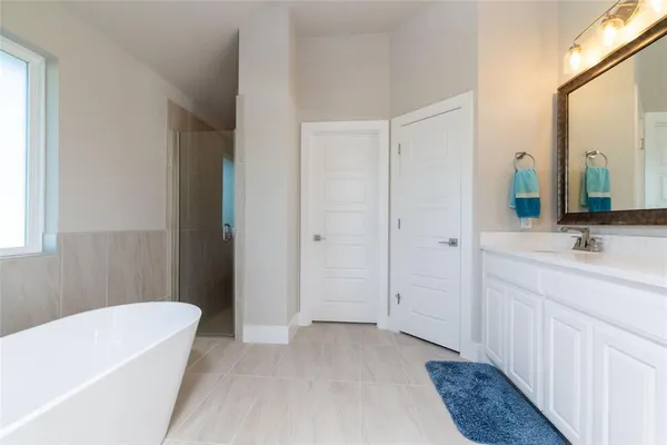 a bathroom with a tub sink and mirror