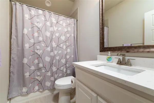 a bathroom with a granite countertop sink mirror vanity and toilet