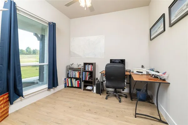 a view of a workspace with furniture and a window