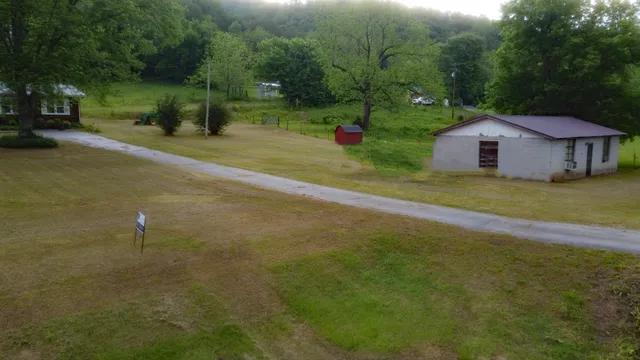 a front view of a house with a yard and trees