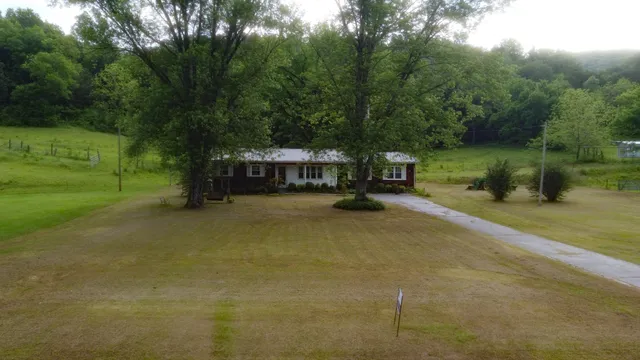 a view of a house with a yard and sitting area